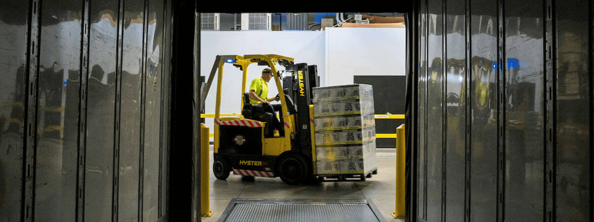 A forklift is seen moving through a warehouse, facilitating the transportation of materials and products.